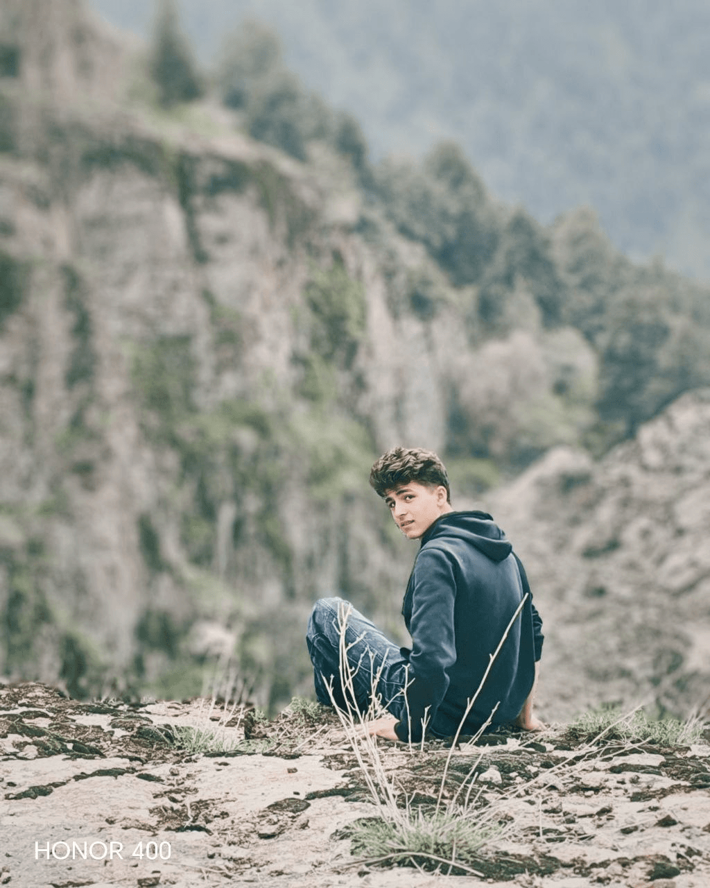 Mus'ab Kamaldinov sitting in a mountain landscape